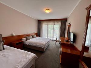 a hotel room with two beds and a television at Hotel Millennium in Pogradec
