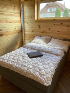 Una cama en una cabaña de madera con un teclado. en MAZURY LAKE RESORT en Wydminy