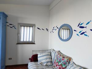 a living room with a couch and a mirror at le finestre sul mare in Conversano