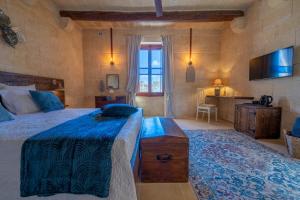 Schlafzimmer mit einem Kingsize-Bett und einem TV in der Unterkunft Home Mood B&B in Għarb