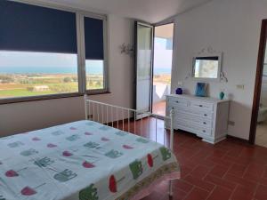 a bedroom with a bed and a dresser and a window at le finestre sul mare in Conversano