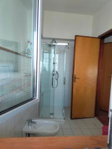 a bathroom with a shower and a sink and a glass door at le finestre sul mare in Conversano