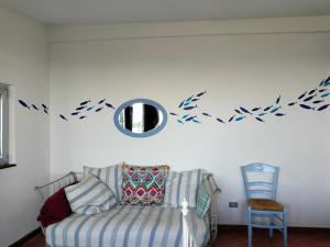 a living room with a couch and birds on the wall at le finestre sul mare in Conversano