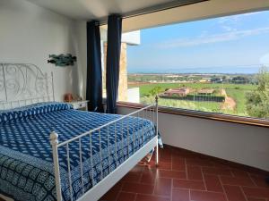a bedroom with a bed and a large window at le finestre sul mare in Conversano
