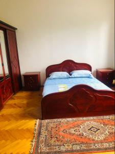 Whole House near the Batumi في باتومي: غرفة نوم مع سرير خشبي كبير مع سجادة
