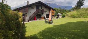 a house with a lawn and an umbrella in front of it at Maison Des Abeilles Vda Gressan n 0028 in Gressan