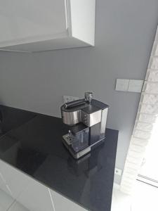 una cafetera sentada en una encimera negra en Apartament Brzeg, en Brzeg