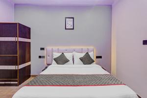 a bedroom with a large white bed with pillows at Townhouse Riddhi Regency Near Indira Nagar Metro Station in Lucknow