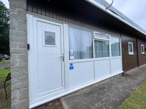 ein Gebäude mit zwei weißen Garagentüren darauf in der Unterkunft 20 Bucklands, Bideford Bay Holiday Park in Bideford