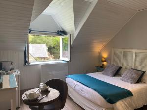 a bedroom with a bed and a window and a table at Les Moulins Du Duc ÉCOLODGE in Moëlan-sur-Mer +114 photos