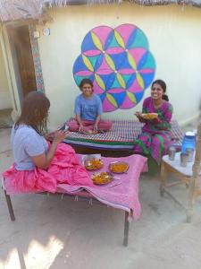 een groep van drie meisjes op een bankje bij Rann of kutch home stay in Dhordo