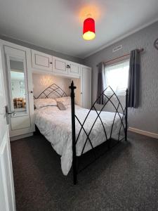 1 dormitorio con 1 cama y luz roja en 20 Bucklands, Bideford Bay Holiday Park, en Bideford