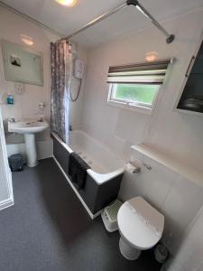 een badkamer met een bad, een toilet en een wastafel bij 20 Bucklands, Bideford Bay Holiday Park in Bideford