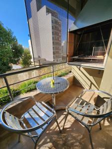 a table and chairs on a balcony with a view of a city at Aires verdes de Capital Depto in Salta