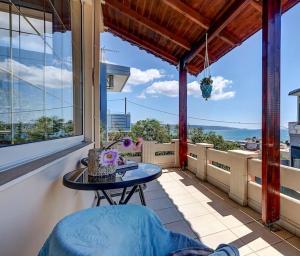 balkon ze stołem i dużym oknem w obiekcie Eva’s Place Panoramic Sea View w mieście Suda