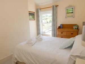 a bedroom with a bed with two towels on it at Studland Cottage in Swanage
