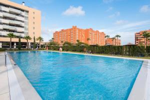 une grande piscine bleue avec des bâtiments en arrière-plan dans l'établissement UNIVERSITY & TECH PARK MALAGA APARTMENT, à Malaga