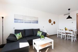 - un salon avec un canapé et une table dans l'établissement UNIVERSITY & TECH PARK MALAGA APARTMENT, à Malaga