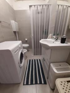 y baño con lavadora y lavamanos. en Appartamento ristrutturato - Castrocaro Terme, en Castrocaro Terme