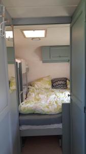 um pequeno quarto com uma cama num pequeno quarto em Sodyba Prie Malūno em Žagarė