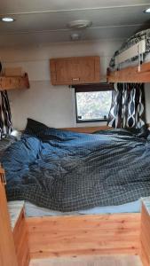 a bed in the middle of a bedroom in an rv at Sodyba Prie Malūno in Žagarė
