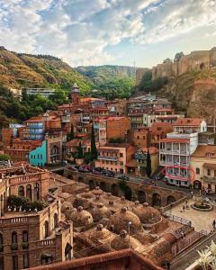 un grupo de edificios en una ciudad con montañas en Apartment in historical district of Tbilisi en Tiflis