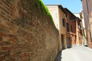 an alley with a brick wall next to a street at Atelier Della Castellina - SELF CHECK IN in Imola