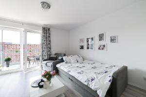 a white bedroom with a bed and a window at Apartment by the sea in Gdańsk