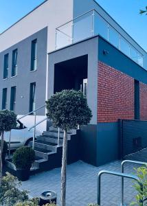 a building with stairs and a tree in front of it at Apartamenty Żary in Żary