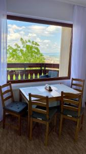 a table and chairs in a room with a large window at BELLESTAY in Braşov