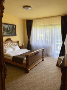 a bedroom with a bed and a large window at BELLESTAY in Braşov