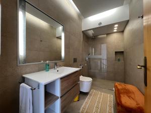 a bathroom with a sink and a toilet and a mirror at Casa Do Pico by AnaLodges in Machico