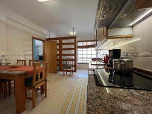 a kitchen with a stove and a table in it at Casa Do Pico by AnaLodges in Machico