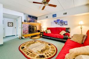 a living room with a red couch and a fireplace at Lakefront Condo with Pool Access-1min to Big Boulder! in Lake Harmony