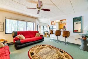 a living room with a red couch and a table at 1 Mi to Big Boulder Lakefront Unit with Pool Access in Lake Harmony