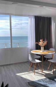 una sala da pranzo con tavolo e vista sull'oceano di Apartamentos de Benidorm, playa Poniente, España a Benidorm