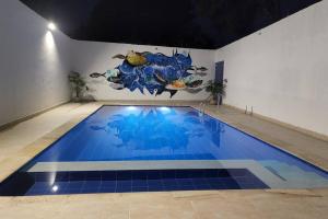 una grande piscina blu con un dipinto sul muro di Casa Villa Palmitas - Tocaima a Tocaima