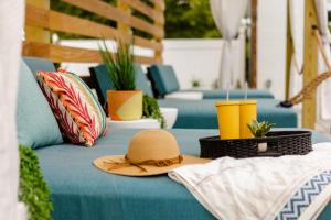 a straw hat sitting on a blue couch with plants at Freebird Motor Lodge by Reverie Boutique Collection in West Yarmouth