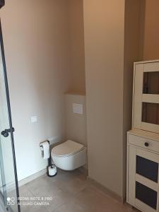 a small bathroom with a toilet and a cabinet at apartament udany wypoczynek in Sarbinowo
