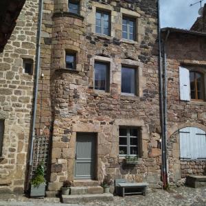 un viejo edificio de ladrillo con un banco delante de él en Gîte de la Tournelle, en Pradelles