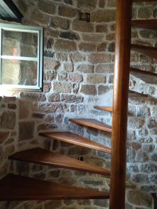 a brick wall with wooden stairs in a room with a window at Gîte de la Tournelle in Pradelles