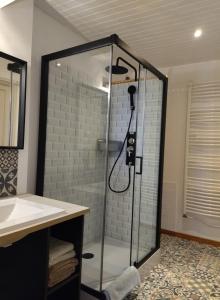 a bathroom with a shower with a glass door at Gîte de la Tournelle in Pradelles