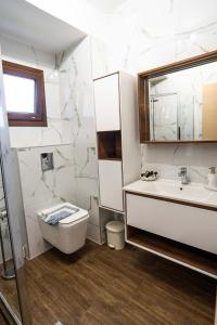 bagno con lavandino, servizi igienici e specchio di Sunset Villa a Hanioti