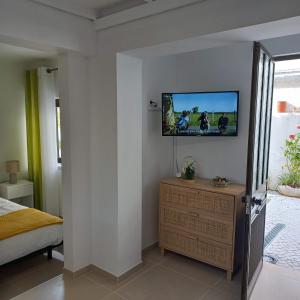 - une chambre avec une télévision murale dans l'établissement Apartamentos Bela Vista, à Nazaré