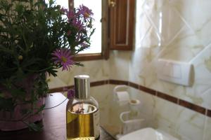 a bottle of oil on a table next to a vase of flowers at Atelier Della Castellina - SELF CHECK IN in Imola +1 photo