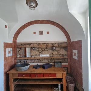 a bathroom with a stone wall and a wooden sink at Apartmány Vila Lucia 2 in Pilsen