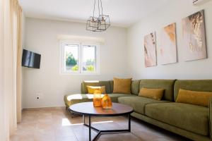 een woonkamer met een bank en een tafel bij Vasilopoulos Residences - Villa Emelia with shared pool in Argostoli