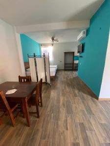 Cette chambre est dotée d'une table, de chaises et d'un mur bleu. dans l'établissement Casa Suites Minizoo, à Puerto Escondido