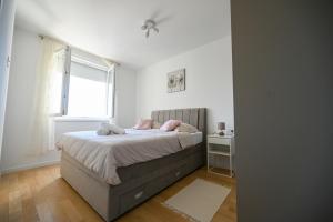 Un dormitorio con una cama con almohadas rosas y una ventana. en Apartman Lovre, en Zadar