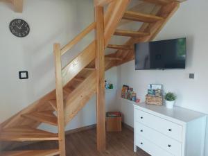 escalera de madera en una habitación con TV en Domki na Stoku en Wisła